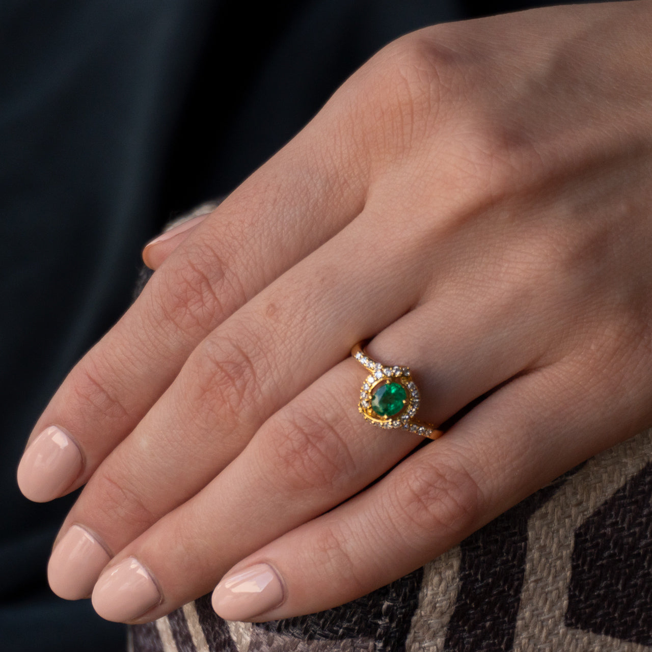 Close-up of a 0.56ct emerald ring on a female hand