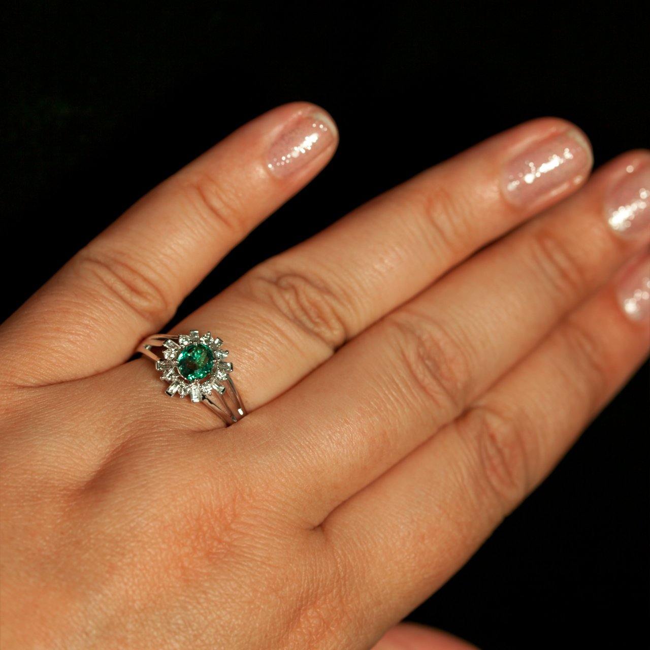Woman's hand showcasing a platinum ring with a 0.78ct natural alexandrite and diamond halo
