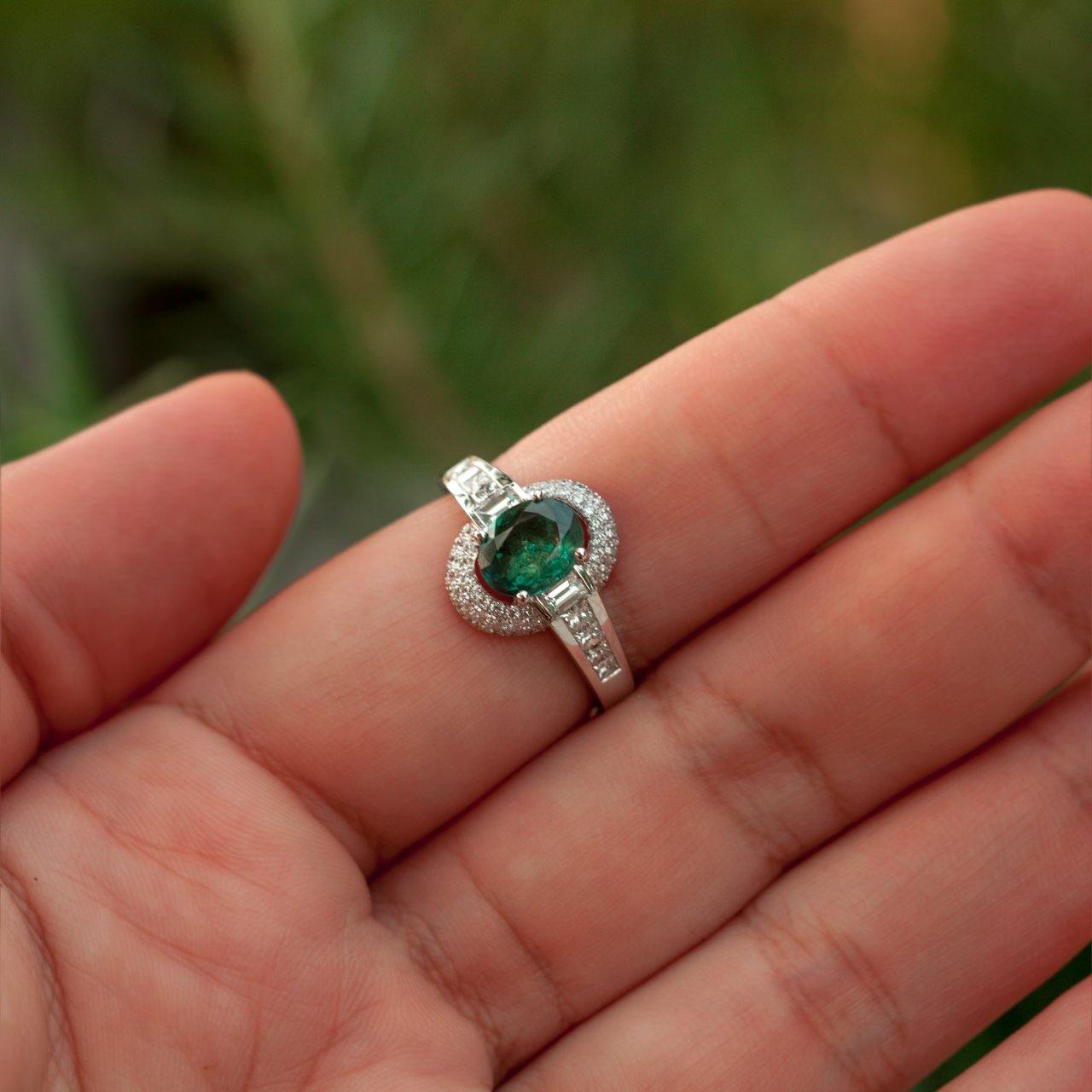Close-up of a hand holding a 1.00ct alexandrite and 18k gold ring