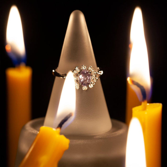 0.68ct alexandrite ring in 18k white gold resting atop a decorative candle holder