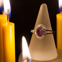 Thumbnail for An 18k gold ring with a 1.00ct alexandrite stone displayed on a candle